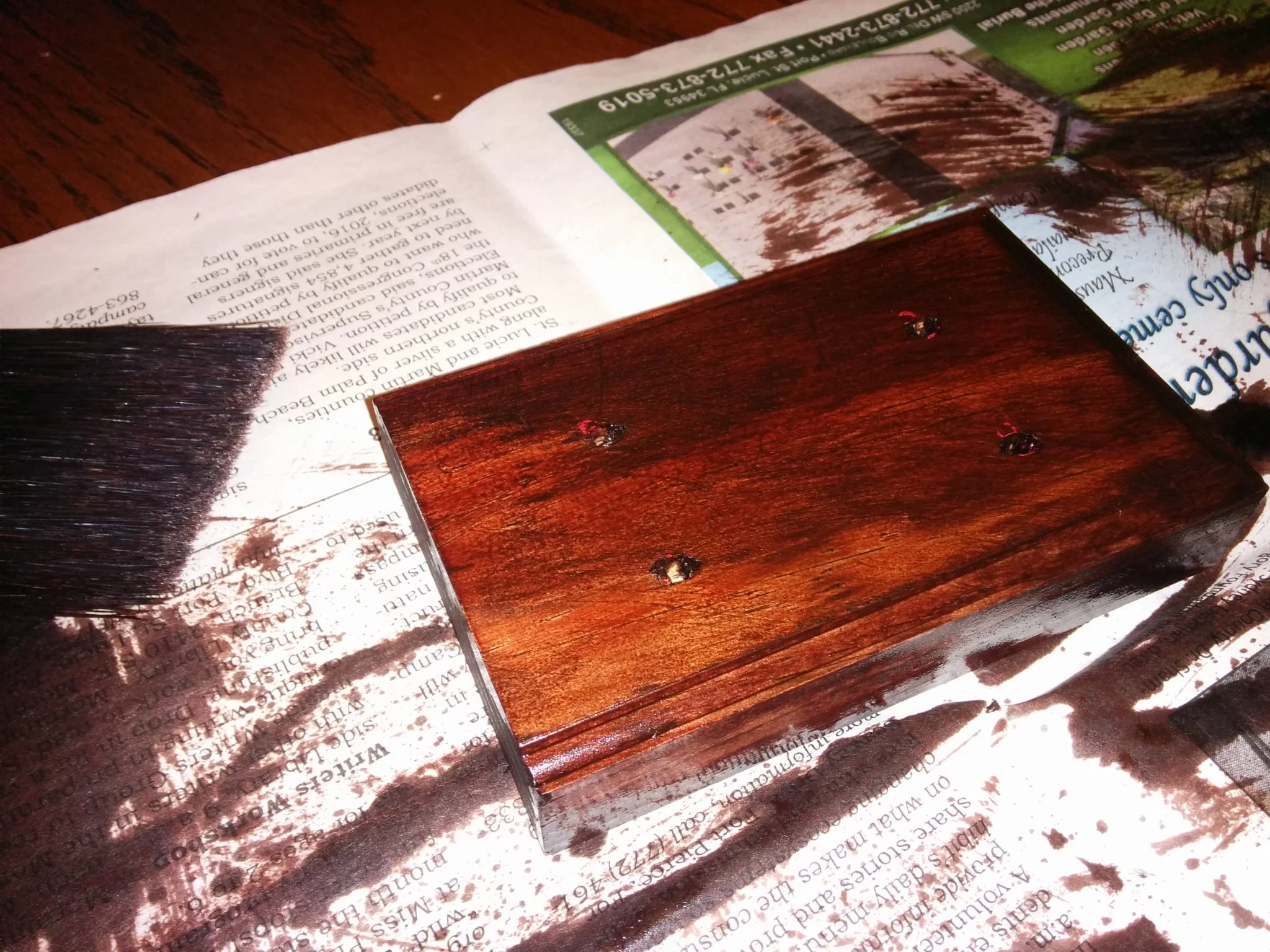 The wooden base, coated in wood finish, drying.
